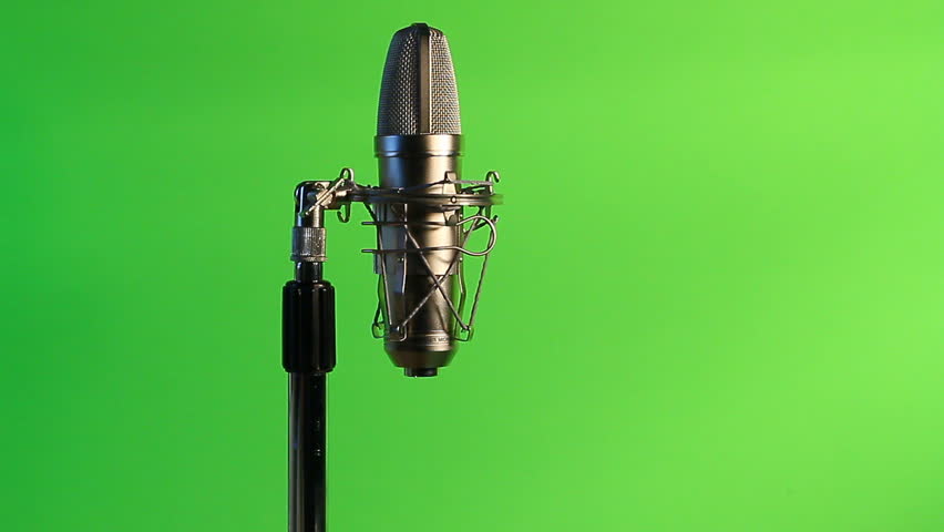 A closeup view of a mic cord being attached to a condenser vocal microphone.Green screen background.
