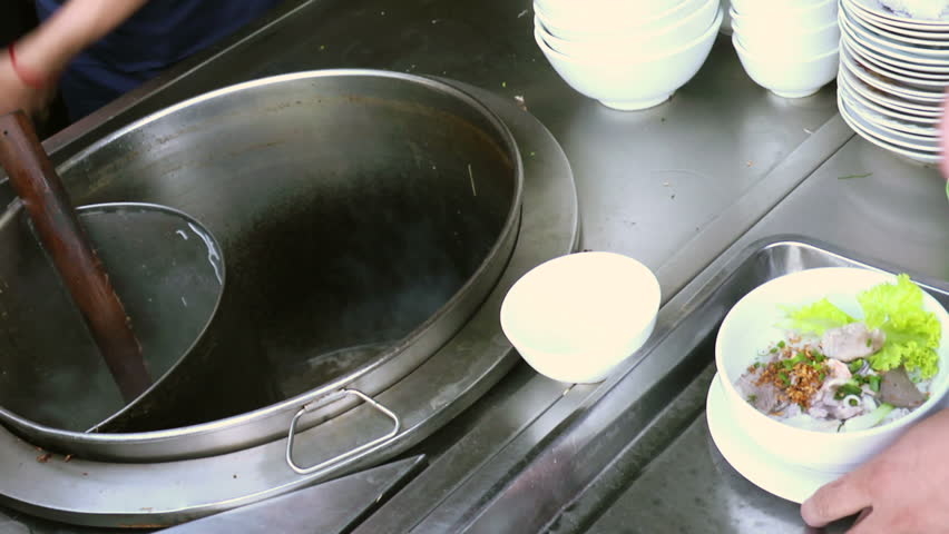 Chef preparing traditional Asian street food and passing noodle soup bowl to waiter in restaurant kitchen, Phnom Penh, Cambodia, Asia. Close-up