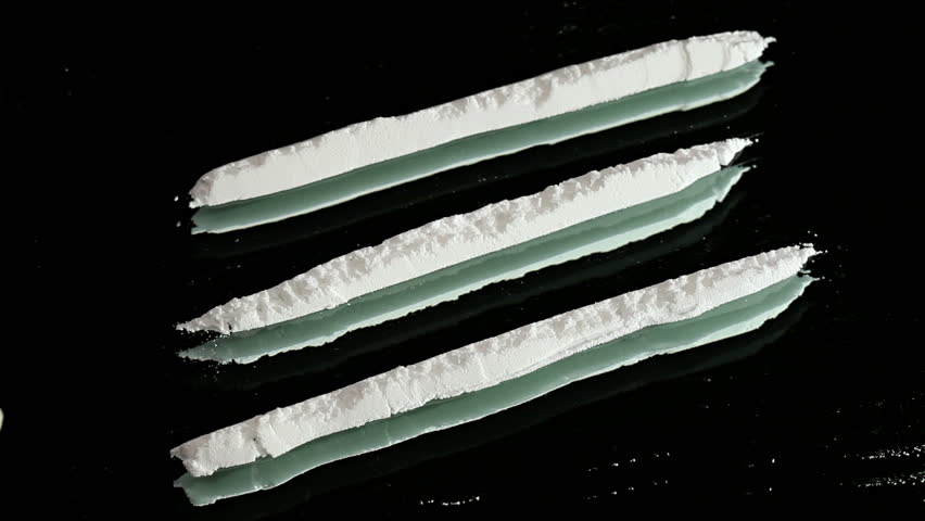 Cocaine snorted on a mirror through rolled 100 dollar bank note, close up view