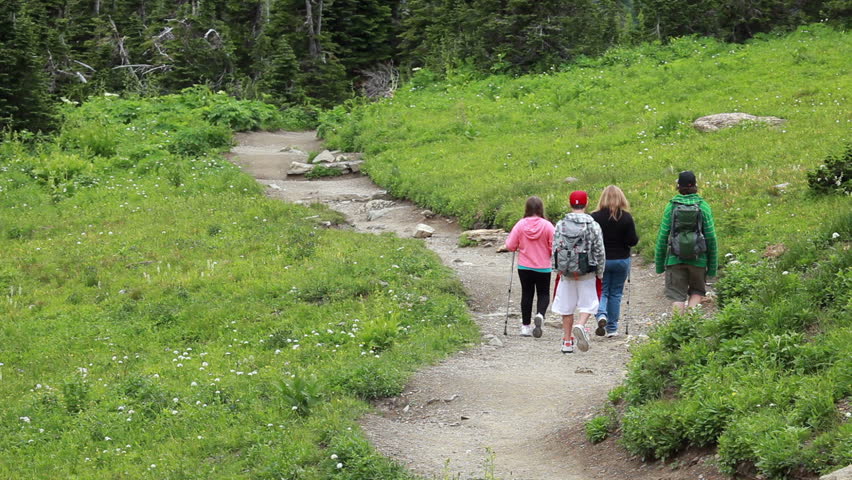 Family, mother and children hike mountain trail for exercise to explore for wildlife in Montana. Family activities important for growth of happy family.
