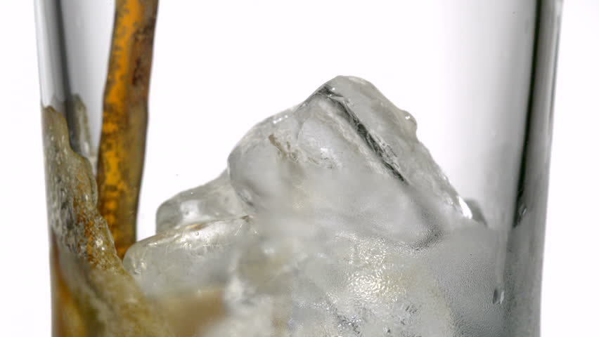 Extreme close-up cola being poured over ice