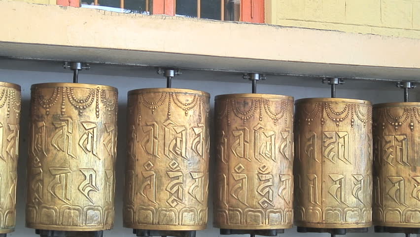MCLEOD GANJ, INDIA - AUGUST 24, 2006: A Tibetan monk spinning prayer wheels