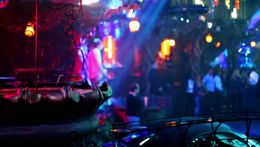 People in night club with colorful illumination, dancer place with twisted lattice