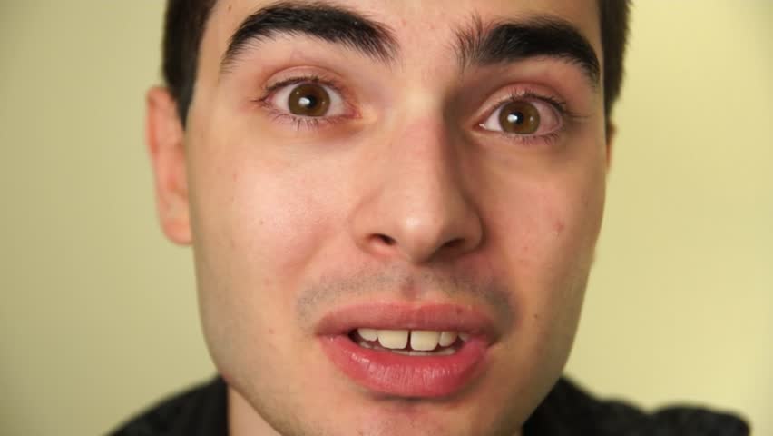 Young man looking directly to the camera and telling a story.