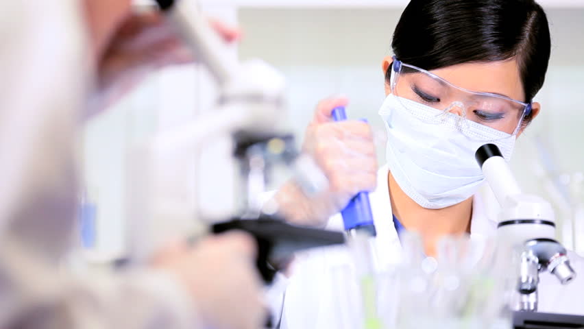 Laboratory researchers working with science equipment in sterile conditions