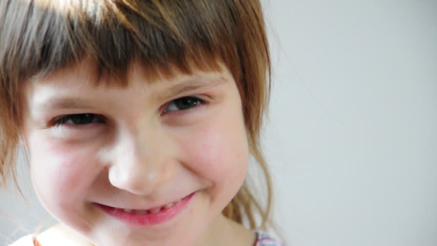 Close-up portrait of a happy little girl bursting in laugh