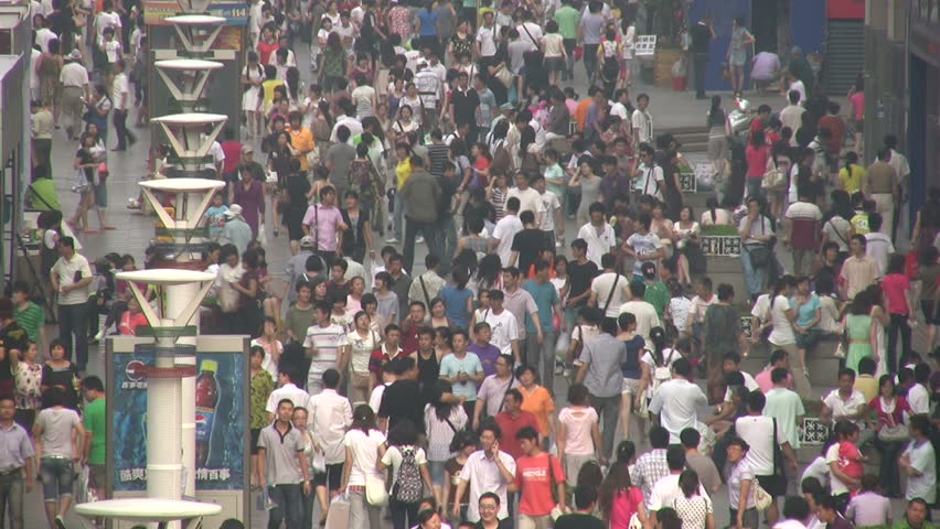 QINGDAO - 7 MAY 2010: Shoppers make their way through a busy street in Qingdao, China