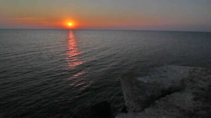 The sun is reflected in a decline by a path in sea water