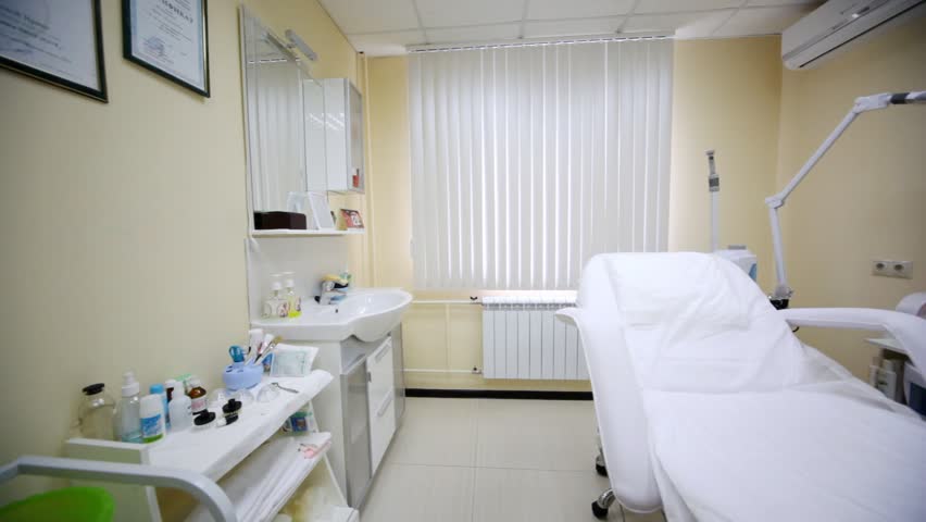 Cosmetology armchair stand at room center in beauty parlour near window and cabinet