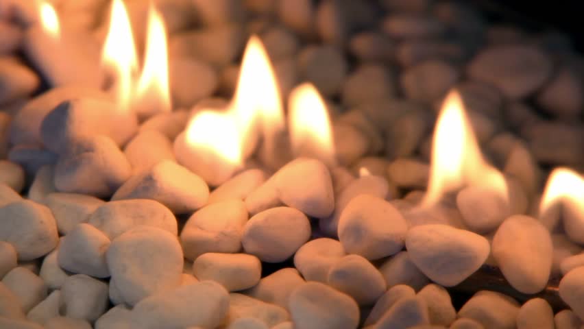 Tongues of flame at white stones pile, closeup view