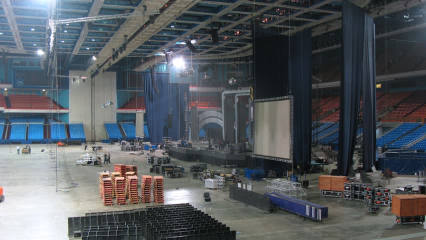 Sceneshifter dismantle construction of scenery and remove from stadium arena, time lapse