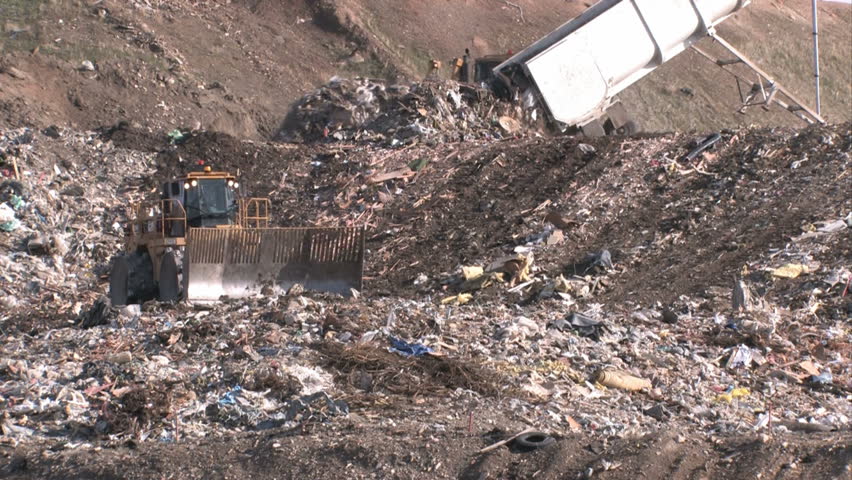 Garbage dump in Utah. Bull dozers moving garbage and trash around. A mountain of a landfill. Pollution and debris from business and residence household waste. Environmental waste non biodegradable.