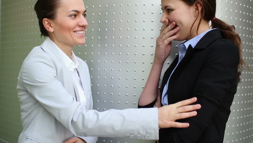 Two woman gossip in the office, camera stabilizer shot