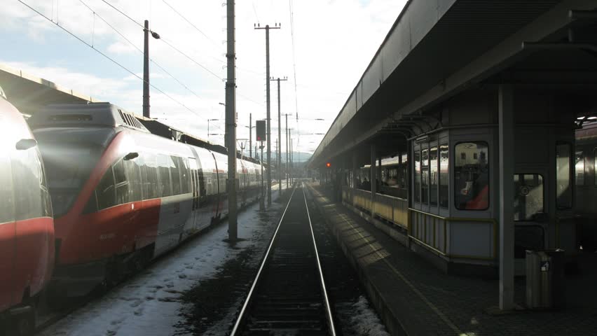 Train goes by rail near with inhabited locality, railway station along electric mains, time lapse