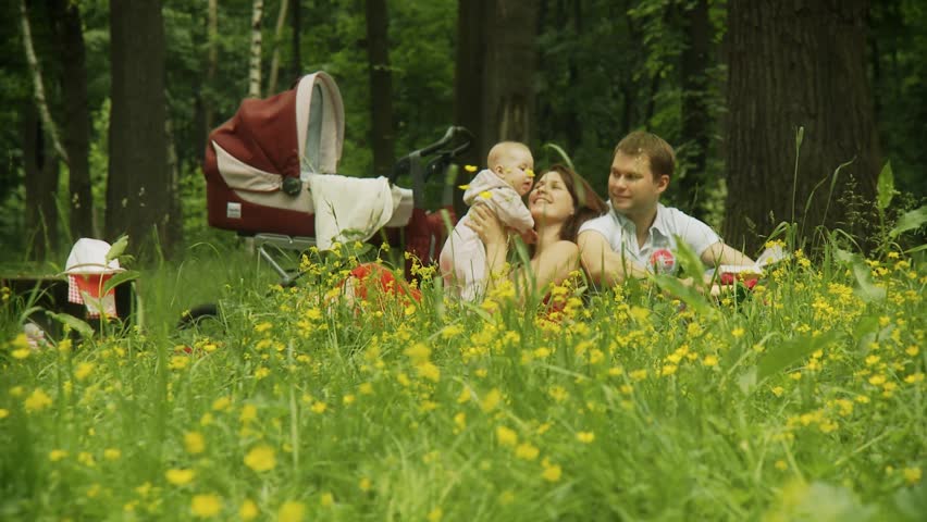Young family of three having a picnic in park