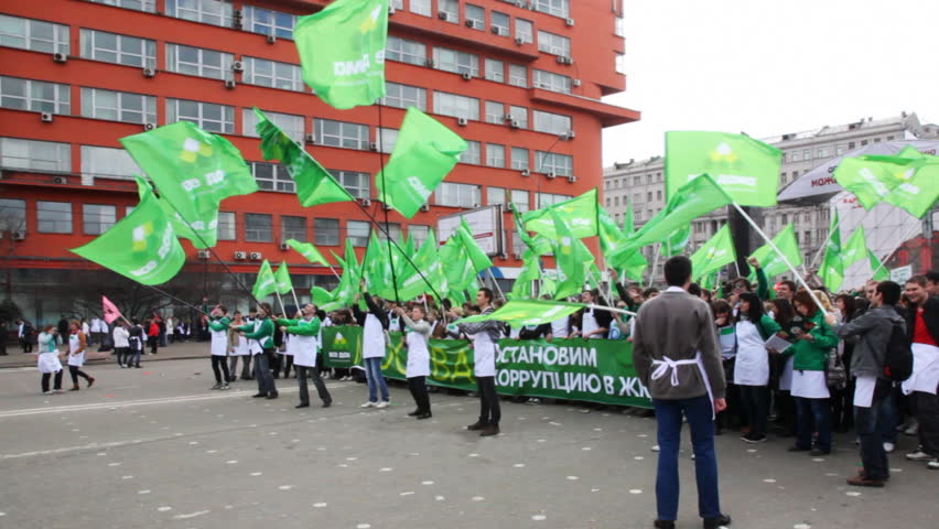 MOSCOW - APRIL 16: People waving large flags in demonstration AGAINST CORRUPTION on Sakharov Ave on Apr 16, 2011 in Moscow, Russia. Supporters dressed in white aprons, as symbol of honesty and fairness