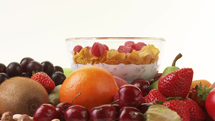 Fresh fruit and bowl of cornflakes, milk and berries
