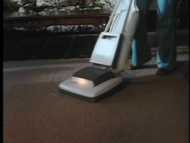 Low angle view of person vacuuming carpet