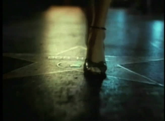 Close-up of woman in high heels strolling on Walk of Fame
