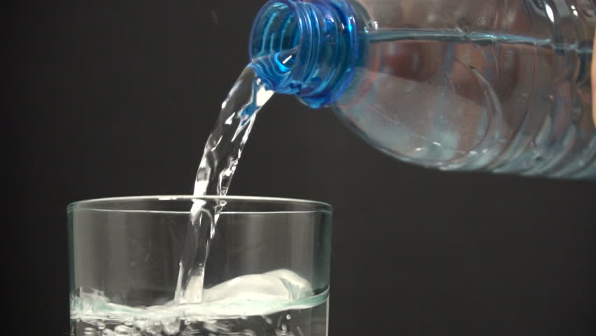 Water From A Plastic Blue Bottle Pouring Into Glass. HD1080i. Stock