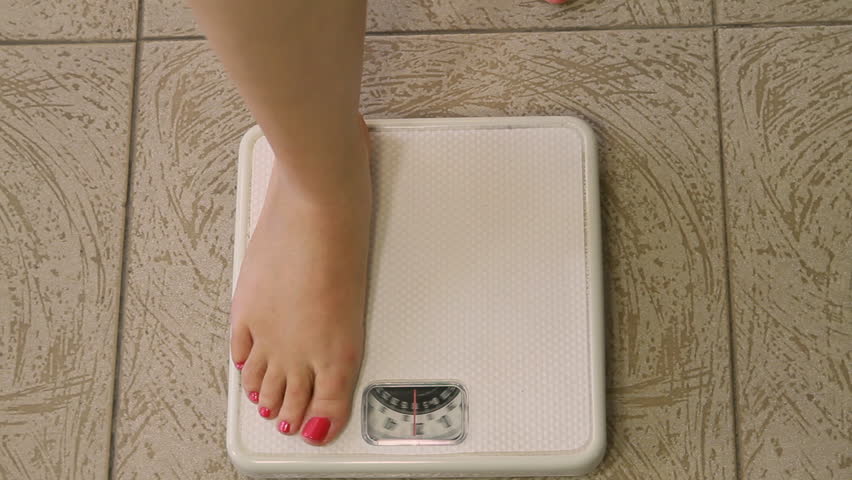Woman on Weight Scale Sequence (HD). Sequence of shots of female legs and feet standing on a weight scale. Passing 200lbs.