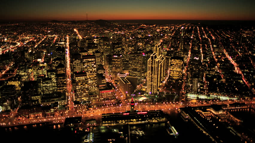 Aerial sunset low angled illuminated view of Fishermans Wharf and San Francisco city skyscrapers, North America, USA