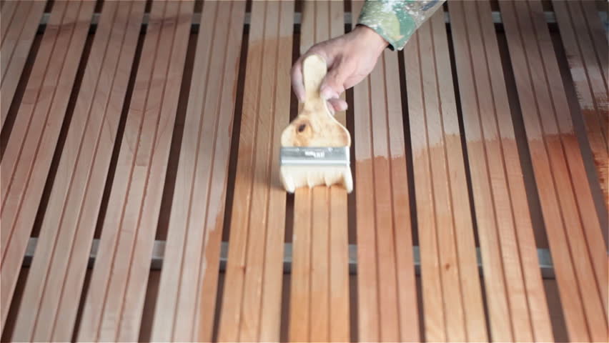 a painter beginning to paint a wood floor.