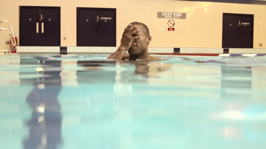 Male jumping into swimming pool in gym