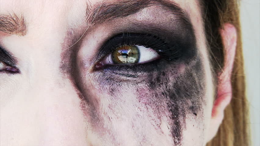 close up of a scared and crying woman with smeared make up