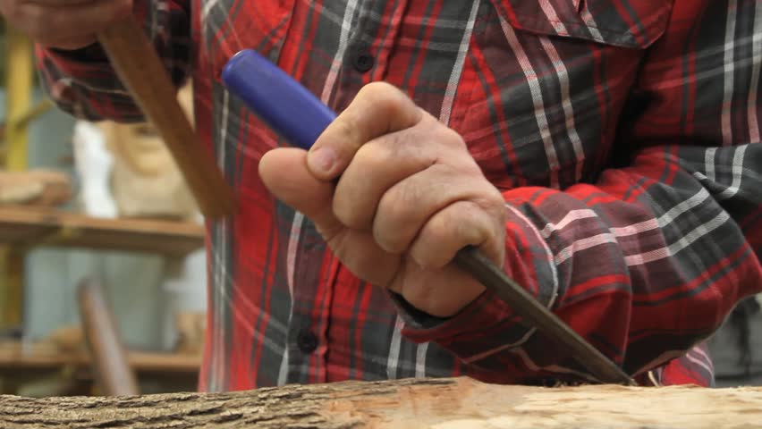 Wood artist working on an Indian figure without seeing the artists face