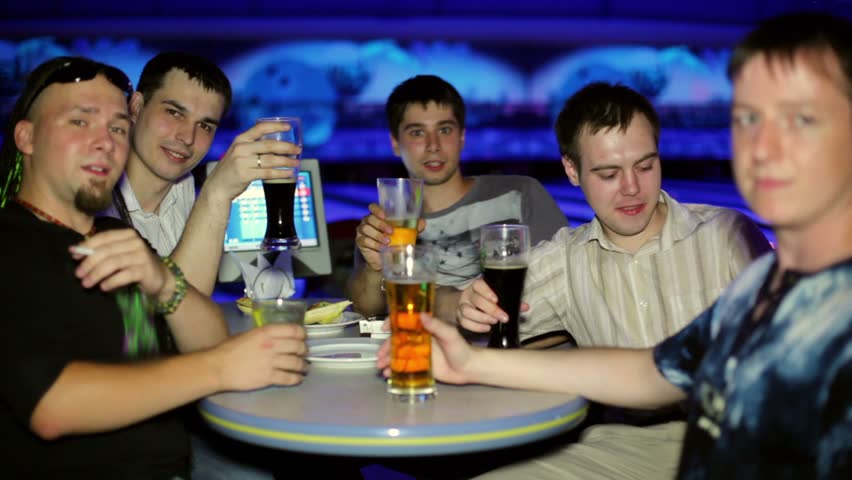 Five friends sit and drink bear in dark bowling club