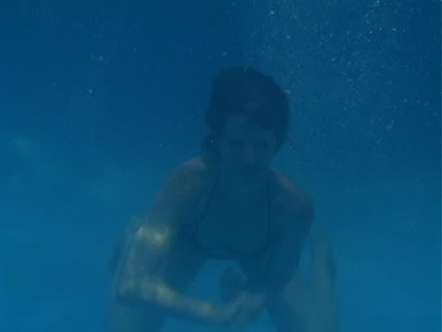A girl in a bikini plays air drums underwater.  Add your own drum track for an exciting and attention-getting clip!