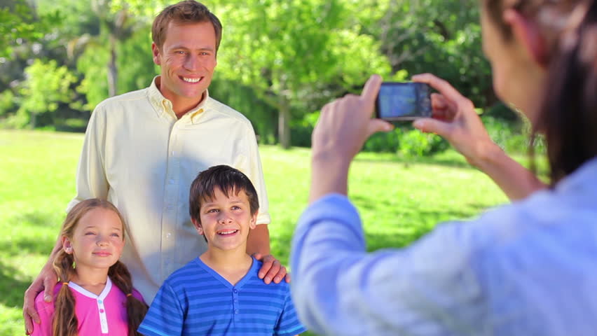 Smiling father standing with his children in a parkland