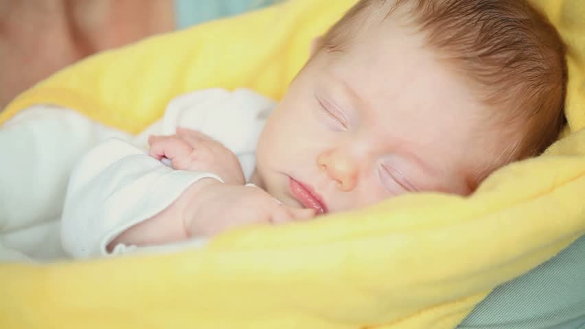 Close-up of a mother kissing her sleeping baby