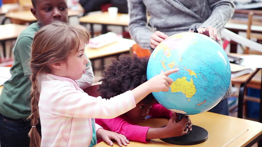 Teacher showing a globe to her pupils in the classroom