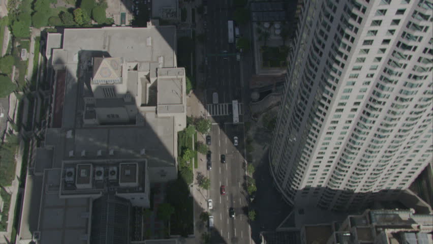 aerial fly by over busy downtown area, buildings casting shadows over the streets circa 2009