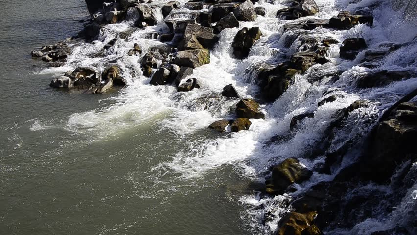 Waterfall cascading down rocks into pool of water