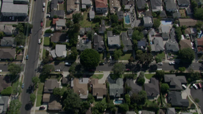 Fly over of homes in a residential area in Southern California separated by a freeway