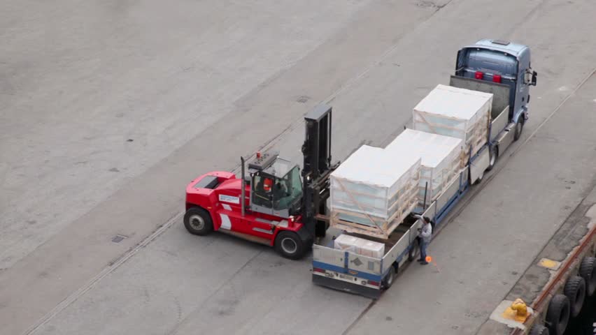 Loader unload truck, labourer walk around and help, view from above