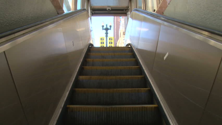 CHICAGO - CIRCA MARCH 2012: Downtown area riding up escalator to city streets from subway during the day.