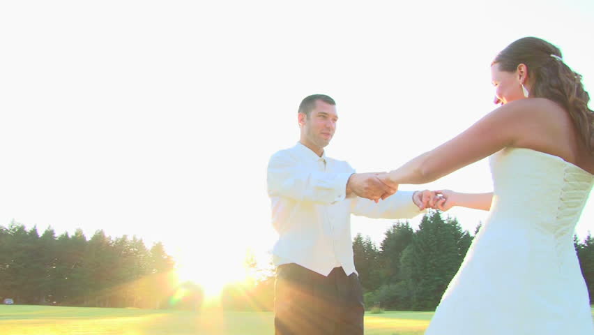 Bride and groom spinning, kissing and smiling on their wedding day.