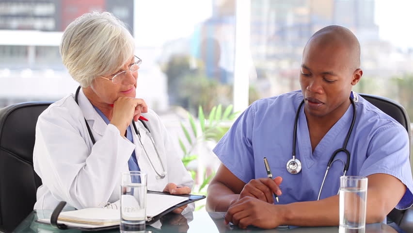 Serious nurse and doctor working together in a bright office