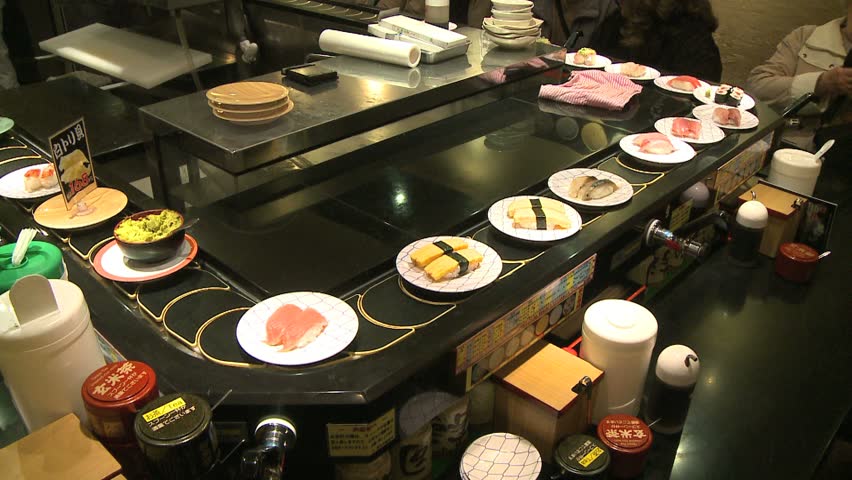 TOKYO, JAPAN - CIRCA 2008: Sushi passing on moving belt around counter