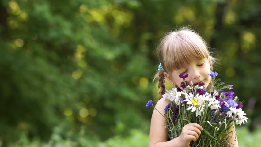 Girl smelling flower in the open space
