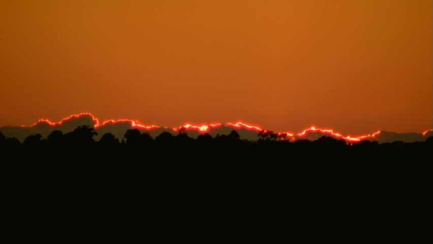 Time lapse of sunrise over fog-filled valley.