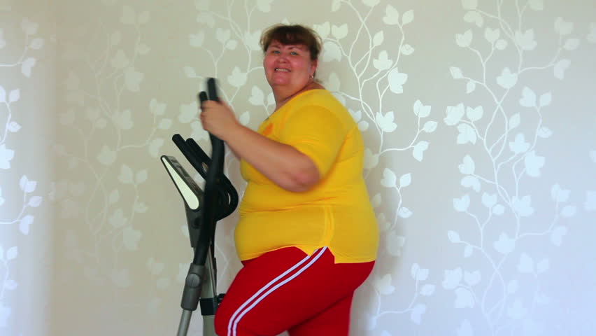 overweight woman exercising on trainer ellipsoid