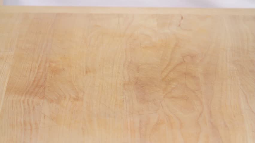 Cherry tomatoes being placed on a work surface