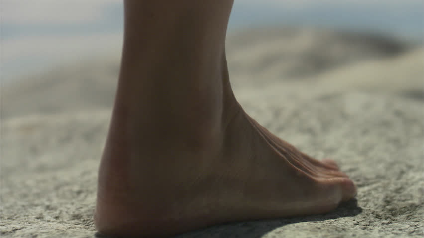 Bare feet walking on cliffs, close-up