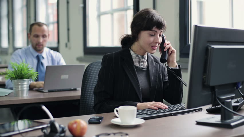 Young attractive businesswoman talking on telephone in the office
