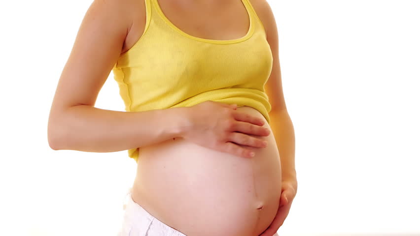 Woman touching her naked pregnant belly

